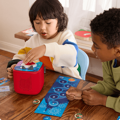 Two children playing the Disney Quiz Tonieplay game on a red Toniebox 2