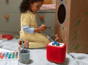 Child painting and playing with Disney and Pixar Toy Story 5- Bullseye Tonie and a red toniebox 2
