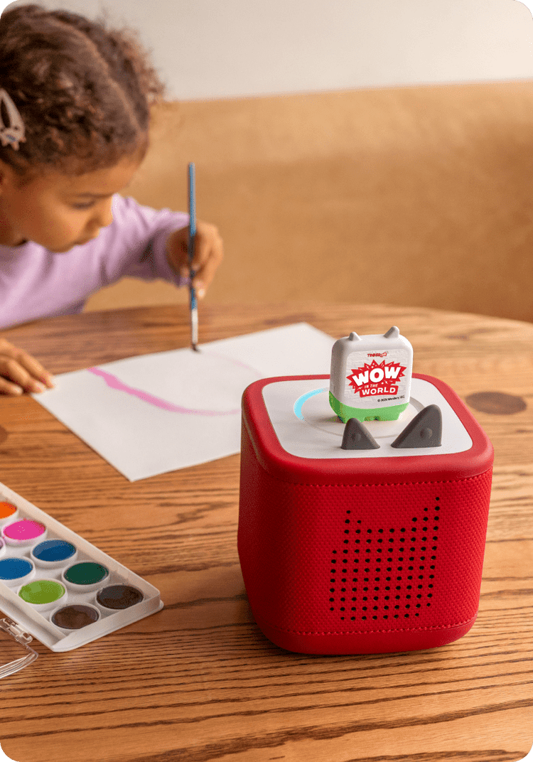 Child painting while listening to WoW in the World Clever Tonie on a red Toniebox 2