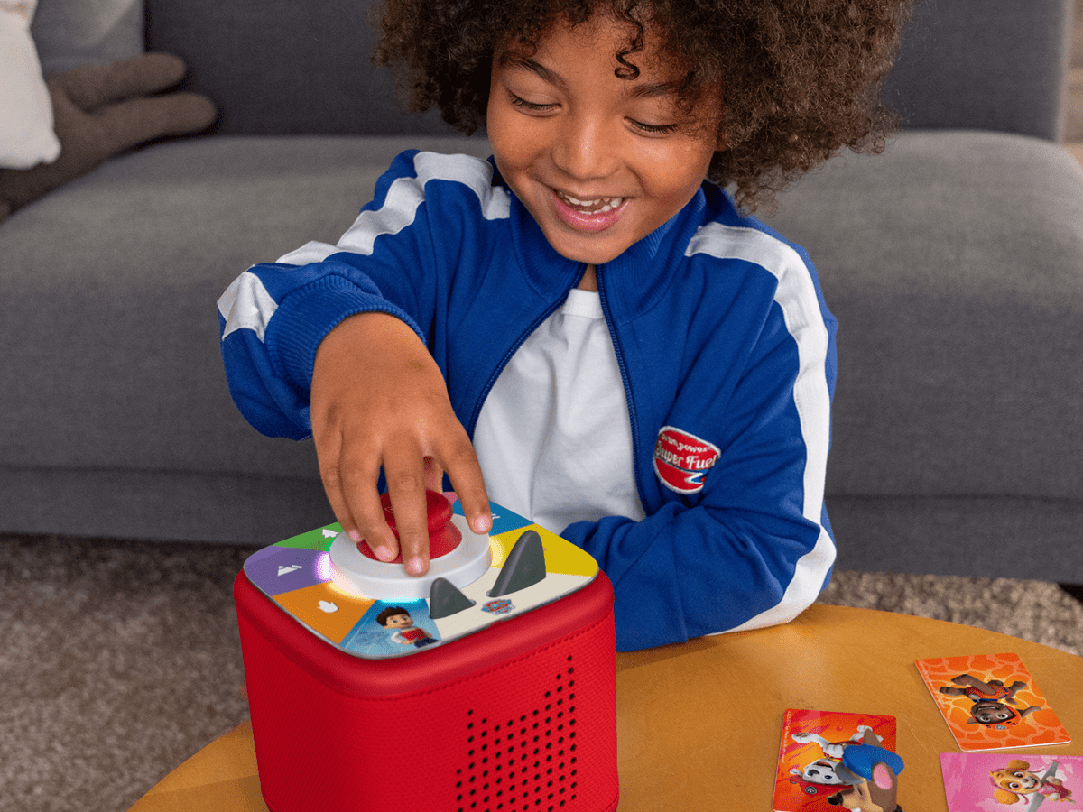 Child using a Tonieplay Controller with a red Toniebox 2 an audio player for kids