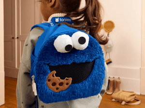 child wearing Toniebox Sesame Street Cookie Monster Backpack used to carry Toniebox, Tonies and accessories