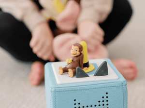 Child Playing With Curious George Tonie