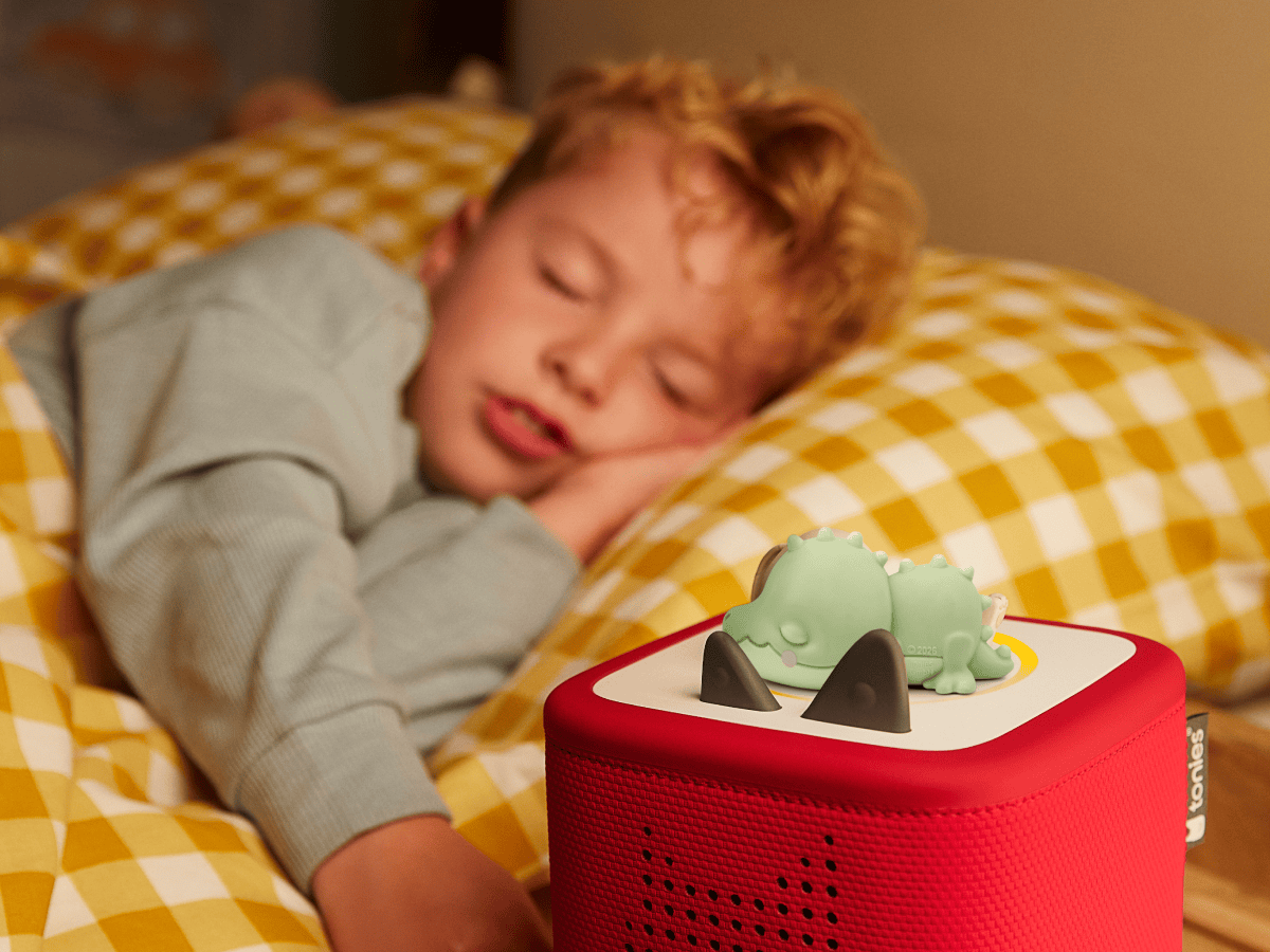 child sleeping in the backgroun with a Doudou Croco tonie on a red toniebox 2