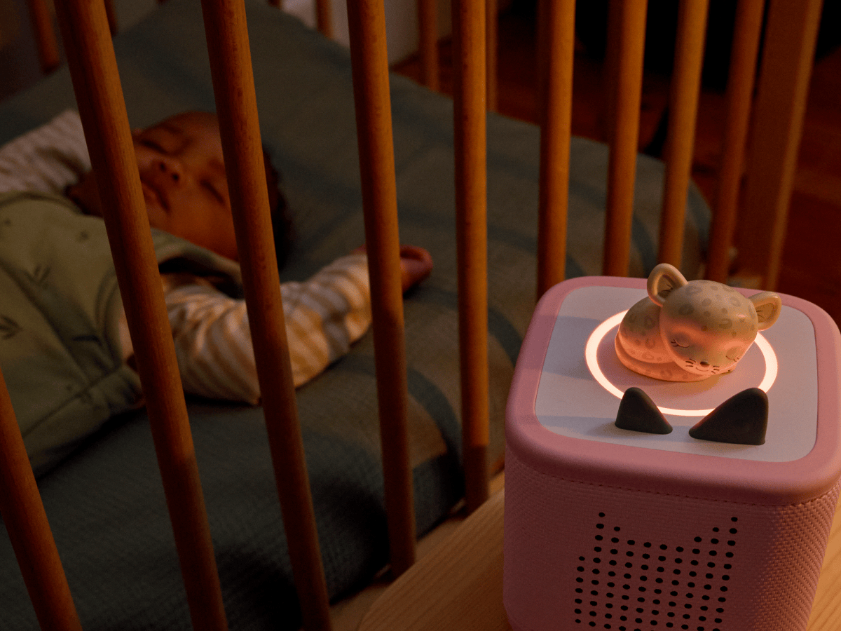 child in a crib next to 
Doudou Jaguar - Berceuses enchantées de la jungle (French) on a pink toniebox 2