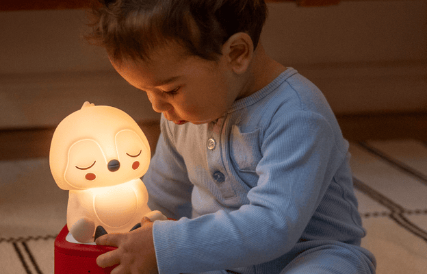 child listening and looking at the Penguin Night light on a red Toniebox 2