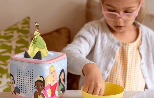 child listening to the The Princess and the Frog Tonie on a pink Toniebox 2 with the Disney Princess sleeve