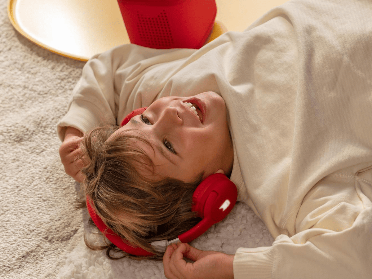 Child Listening To The Toniebox 2 And Tonie With Red Bluetooth Headphones For Kids
