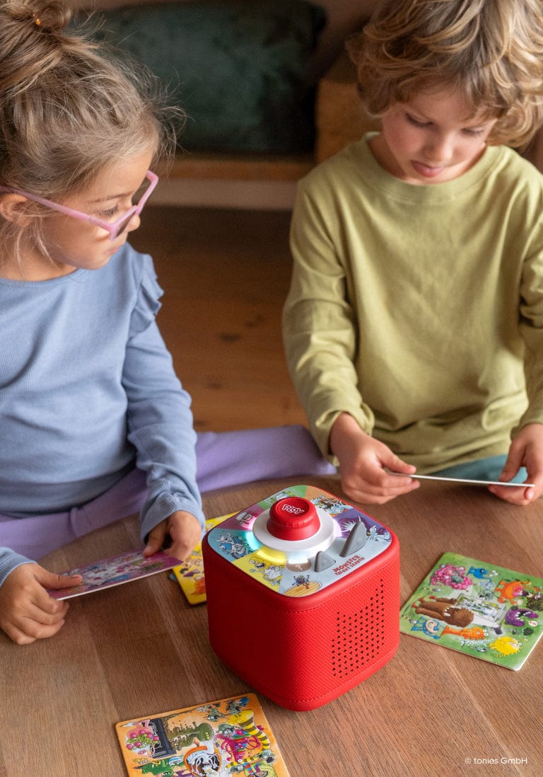 two children playing a Tonieplay game on a red Toniebox 2