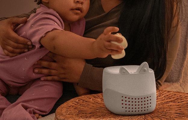 mother holding child while the child places sleepy duck Tonie onto a grey Toniebox Lite