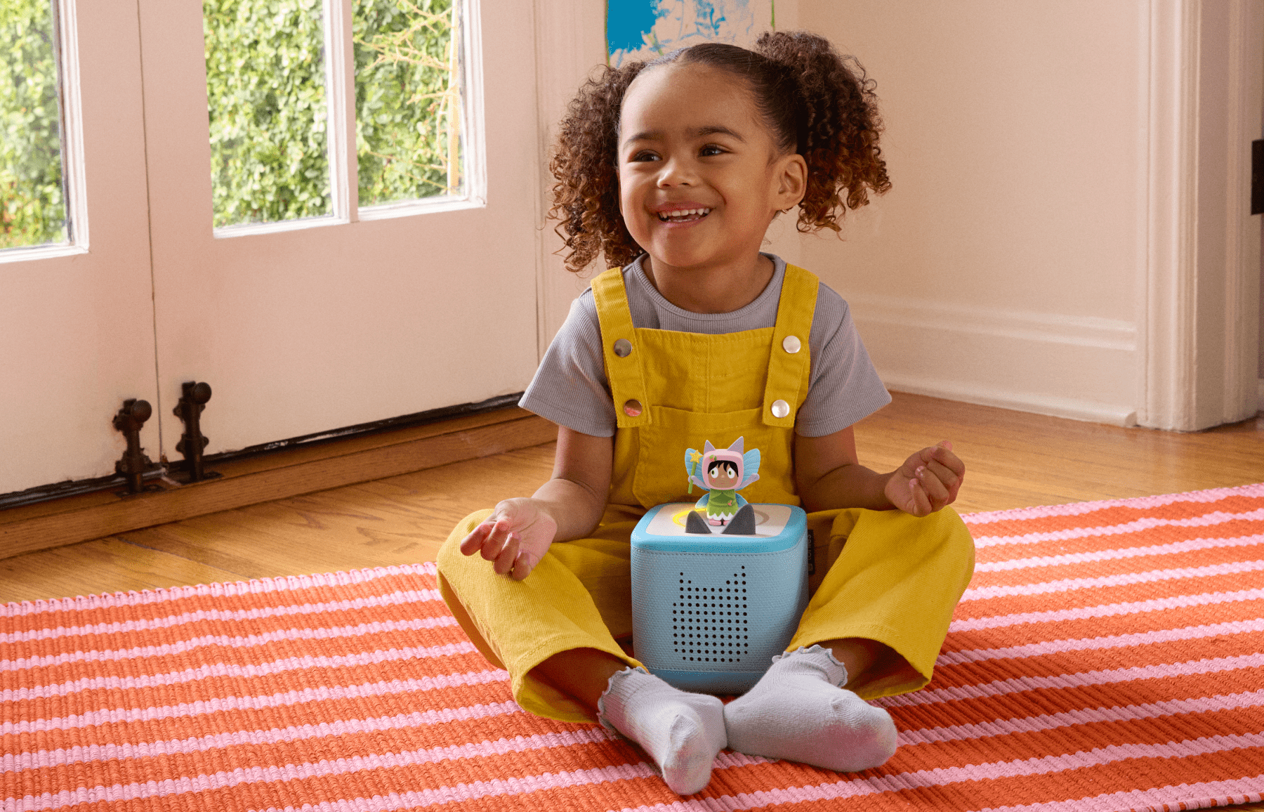 Child sitting on the floor with a blue Toniebox 2 and Fairy Creative Tonie