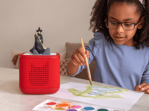 Child playing with Wicked Tonie audio figurine and Toniebox 2