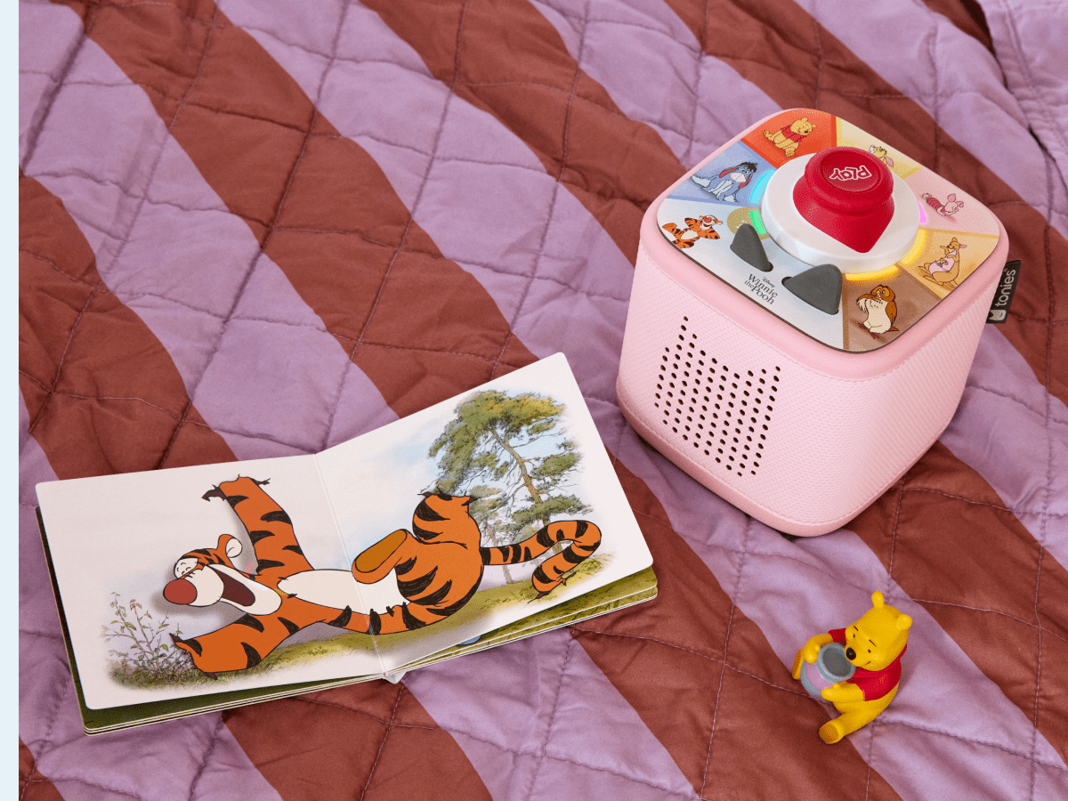 child playing with pink Toniebox 2, tonieplay controller, Winnie the Pooh tonie and disney tonieplay game