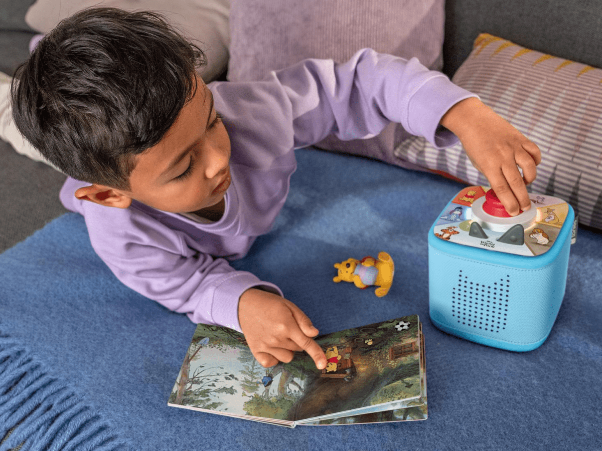 child playing with Toniebox 2 an audio player for kids with Winnie the Pooh Tonie audio figurine and Winnie the Pooh Tiggers Mixup Fixup Tonieplay Game