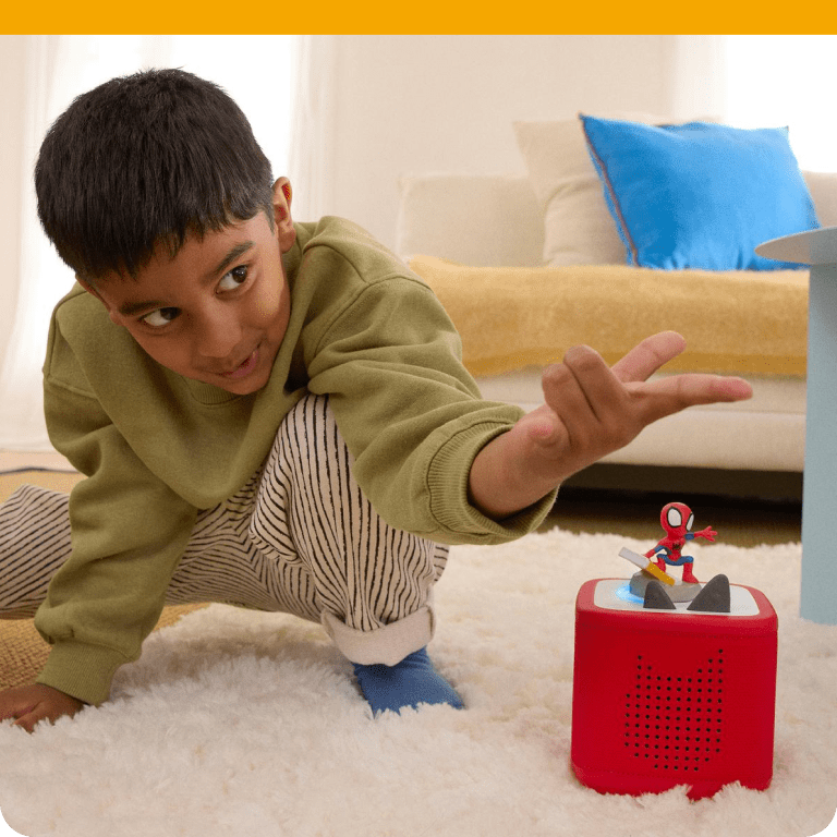 Child playing with a red Toniebox 2 and Spidey Tonie