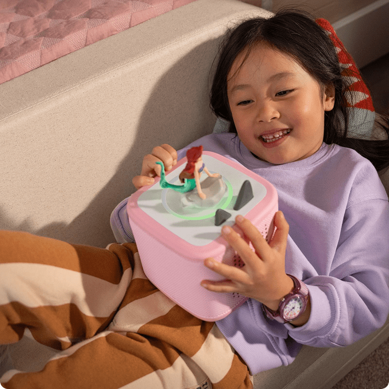 child listening to the Little Mermaid Tonie on a pink Toniebox 2