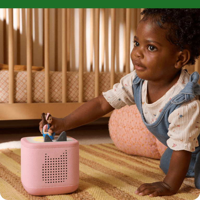 young child playing with the Ms. Rachel Tonie on a pink Toniebox 2
