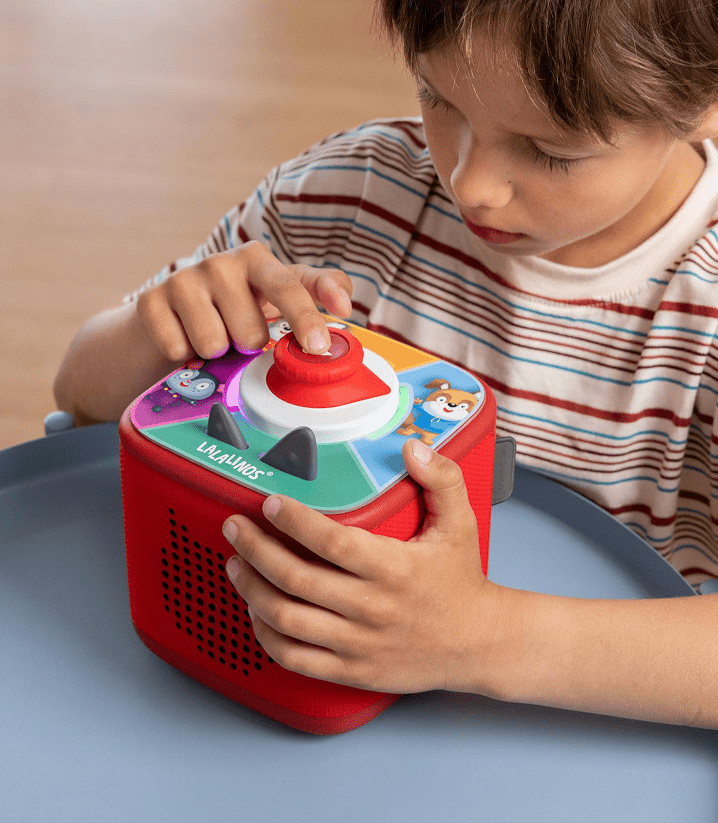 Child playing a Tonieplay game with controller on a red Toniebox 2