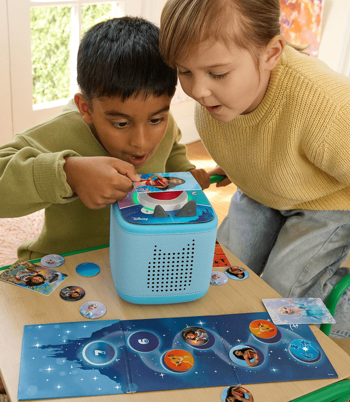 two children playing Disney Tonieplay game with controller and blue Toniebox 2
